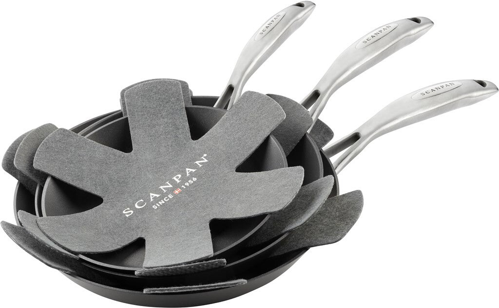 Tre SCANPAN pandebeskyttere placeret mellem stablede stegepander