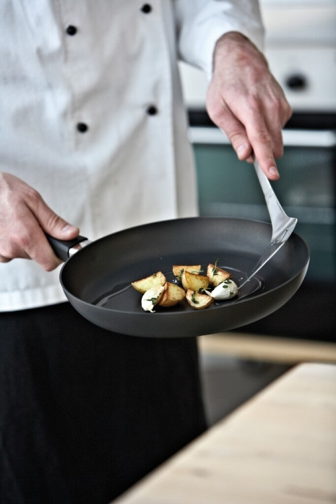 Ein Koch brät Gemüse in einer SCANPAN Classic Bratpfanne