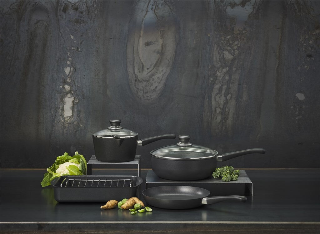 SCANPAN Classic Töpfe und Pfannen mit Gemüse auf einer dunklen Küchenfläche