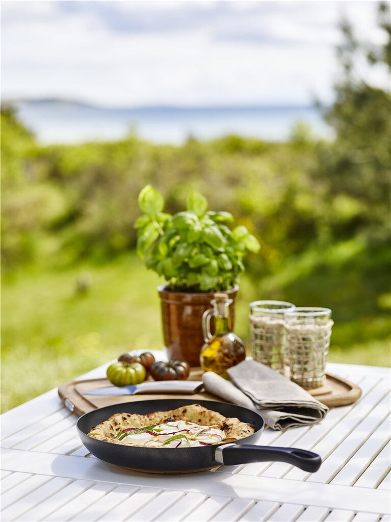 Pizza in einer SCANPAN Classic Induction Bratpfanne vor dunklem Hintergrund