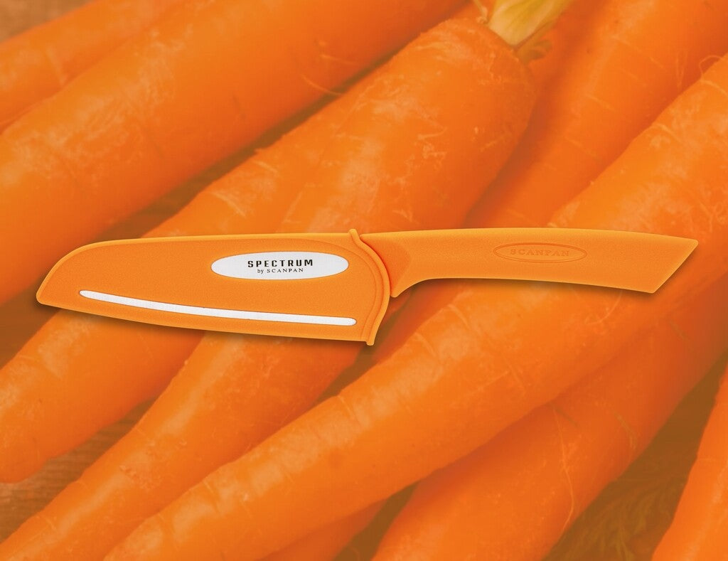 Spectrum santoku knife in Carrot Curl shown in use