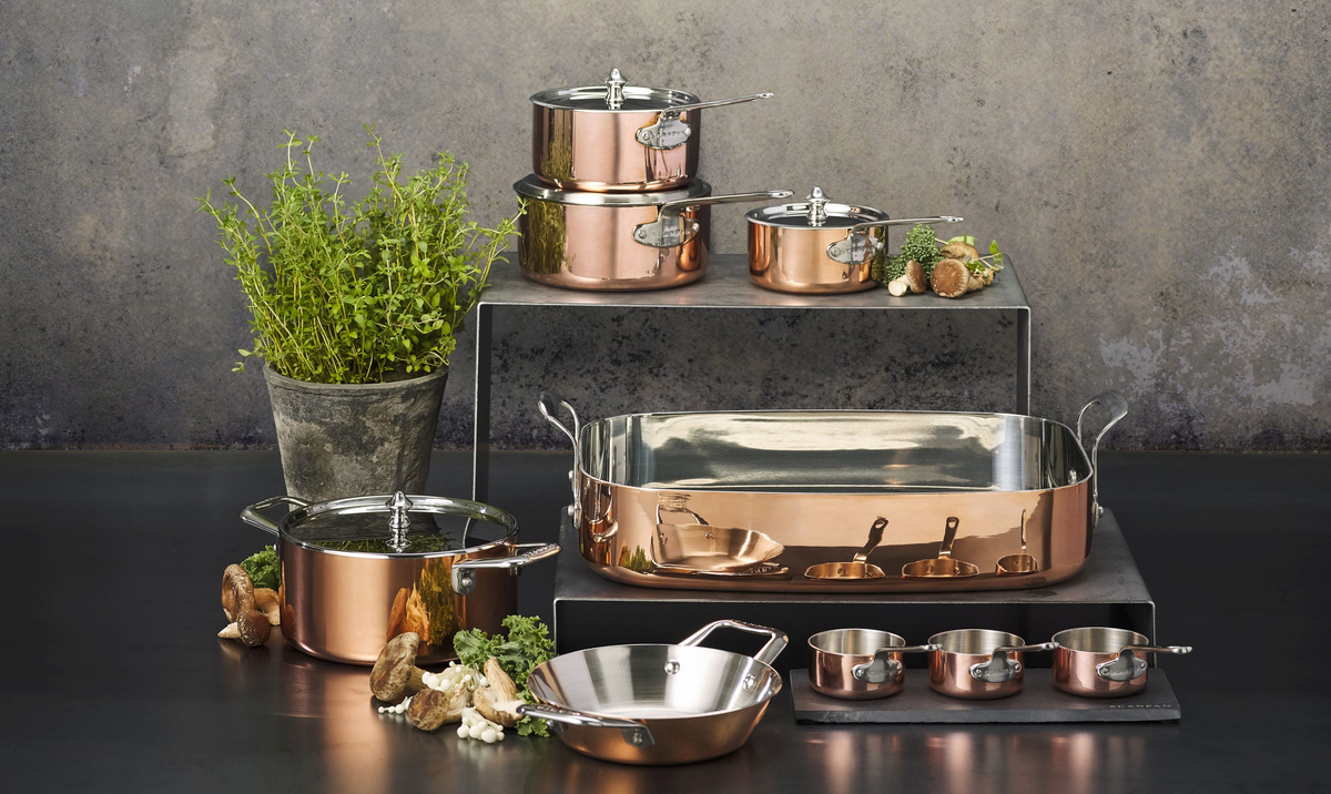 Selection of SCANPAN Maitre D' copper cookware on a dark background